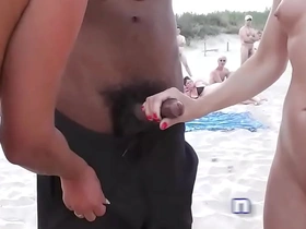 Naomi and her companion pleasure themselves on the public shore